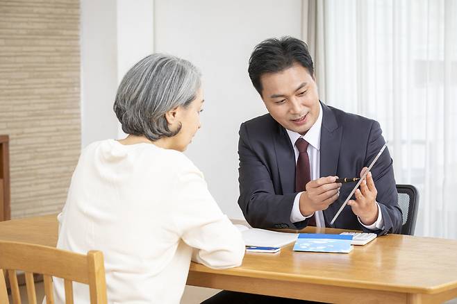 한 고객이 금융상품에 대한 설명을 듣고 있다. 사진제공=클립아트코리아
