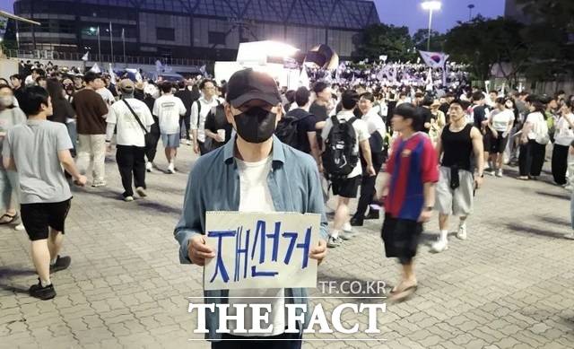 장동혁 국민의힘 대표가 지난 6일 서울 송파구 올림픽공원 핸드볼경기장에 설치된 개표소 앞에서 투표용지 부족 사태에 항의하며 재선거를 요구하는 손피켓을 든 모습. /뉴시스