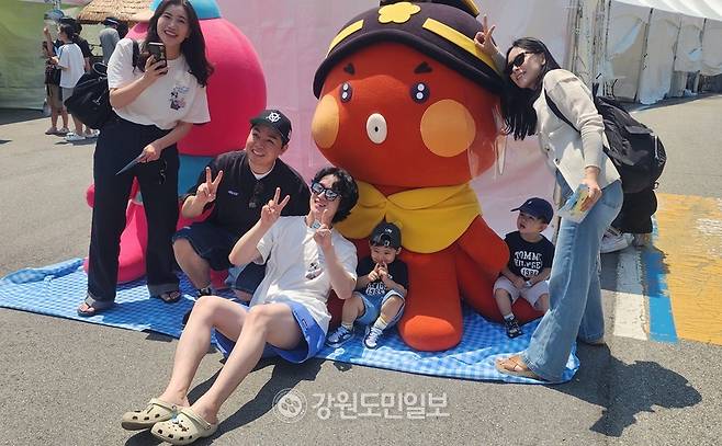 ▲저도 대문어축제가 성황리에 열리고 있는 대진항 대문어 캐릭터와 함께 경기 부천에서 온 젊은 관광객들이 기념 사진을 찍고 있다. 김주현 기자