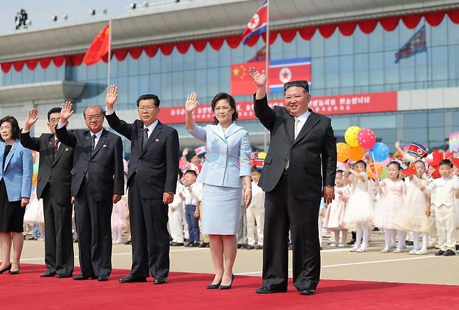 김정은 북한 국무위원장과 부인 리설주가 9일 평양 순안국제공항에서 귀국하는 시진핑 중국 국가주석 일행을 향해 손을 흔들고 있다 . 평양=노동신문 뉴스1