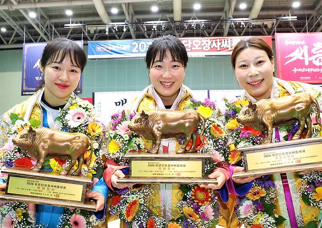 9알 ‘2026 보은단오장사씨름대회’ 여자부 개인전에서 우승한 최다혜(왼쪽부터)·양윤서·김다영 선수가 황소트로피를 들어 보이고 있다. 대한씨름협회