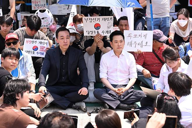 16일 국민의힘 장동혁(가운데에서 오른쪽) 대표와 김민수(가운데 왼쪽) 최고위원이 6·3 지방선거 잠실 개표소로 쓰였던 서울 송파구 올림픽공원 핸드볼경기장 앞에 앉아 있다. 장 대표는 이날 “지금 시민이 원하는 건 재선거, 특검, 선관위 개혁”이라며 “대통령과 민주당이 이에 대해 어떤 답도 내놓지 않으면서 강제 해산을 시도하면 결국 민심의 역풍을 맞게 될 것”이라고 했다. /장경식 기자