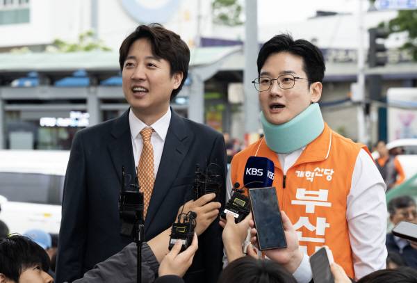 개혁신당 이준석 대표와 정이한 개혁신당 부산시장 후보가 지난 4월 말 부산 북구 구포시장을 찾아 발언하고 있다. 정이한 후보는 전날 시민이 던진 음료수를 피하다 다쳐 석고붕대를 했다. 국제신문DB
