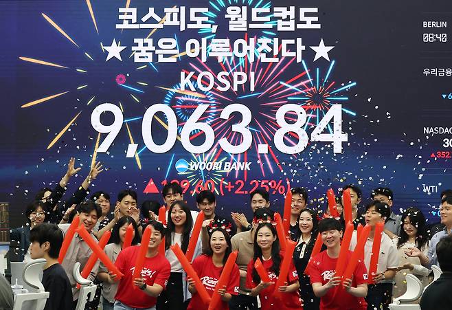 코스피가 사상 처음으로 종가 기준 9000선을 돌파하며 장을 마친 18일 서울 중구 우리은행 본점 딜링룸에서 직원들이 축하 세리머니를 하고 있다. 연합뉴스