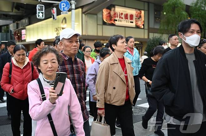일본 도쿄 긴자의 쇼핑가에서 지난해 11월 17일(현지시간) 중국인 관광객이 도로를 건너고 있다. 2025.11.17 ⓒ AFP=뉴스1