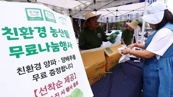 지난 9일 서울 중구 청계광장에서 열린 '2026 유기농데이' 행사에서 시민들이 친환경 양파를 받고 있다. 연합뉴스