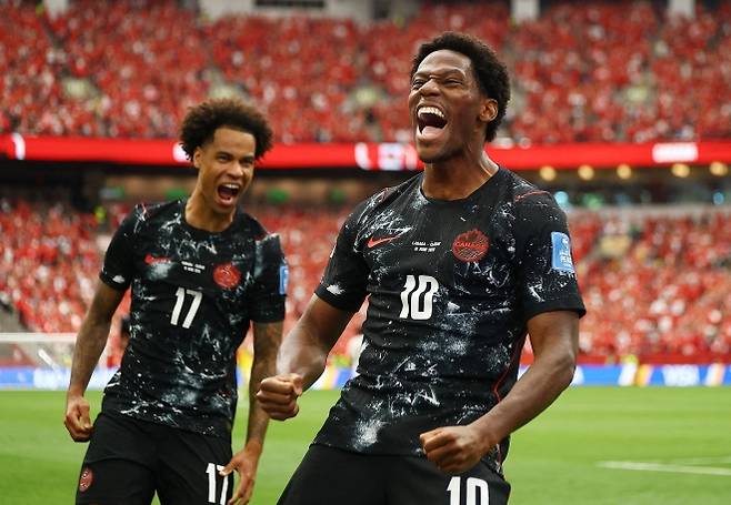 캐나다 축구대표팀의 조너선 데이비드(오른쪽)가 19일(한국시간) 캐나다 밴쿠버 BC플레이스에서 열린 2026 국제축구연맹(FIFA) 북중미월드컵 조별리그 B조 2차전 카타르와의 경기에서 팀의 두 번째 득점을 올린 뒤 기뻐하고 있다. 이날 캐나다는 카타르를 6-0으로 완파하며 역사적인 첫 월드컵 본선 승리를 기록했고, 데이비드는 해트트릭을 작성했다. 밴쿠버 로이터 연합뉴스