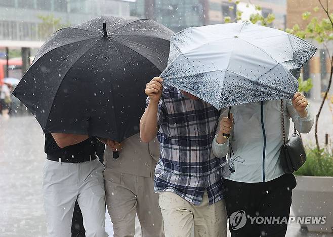 '강풍을 동반한 비' (서울=연합뉴스) 한종찬 기자 = 소나기가 내린 14일 서울 종로구 광화문광장에서 시민들이 우산으로 바람과 비를 막고 있다 . 2026.6.14 saba@yna.co.kr