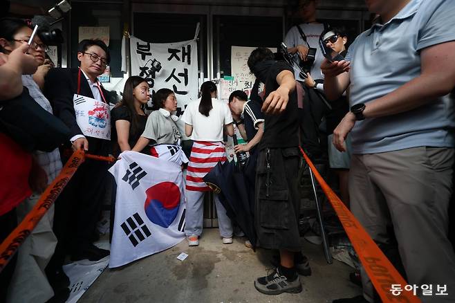 6.3지방 선거에서 투표용지가 부족한 사태에 대해 부정선거라고 주장하는 시민들이 서울 송파구 개표소인 올림픽공원 내 핸드볼경기장 출입을 봉쇄한 가운데 16일 오후 14시 50분 시민 한 명이 문을 가로 막아 체육회 인원들과 국민의힘 의원들이 건물 안으로 들어가지 못하고 있다. 변영욱 기자 cut@donga.com