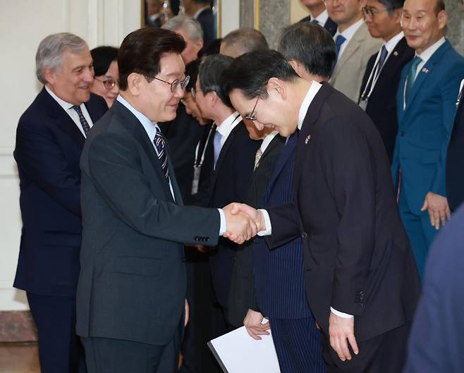 이재명 대통령이 12일 이탈리아 로마의 한 호텔에서 열린 비즈니스 라운드테이블에 입장하며 이재용 삼성전자 회장과 악수하고 있다. 로마=연합뉴스