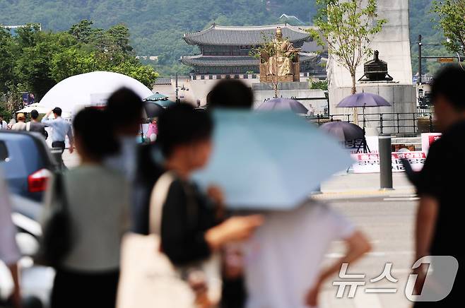 서울 전역에 올해 첫 폭염주의보가 발표된 29일 오후 서울 종로구 광화문 네거리에서 시민들이 횡단보도 그늘막 아래에 모여 햇볕을 피하고 있다. 2026.6.29 ⓒ 뉴스1 오대일 기자