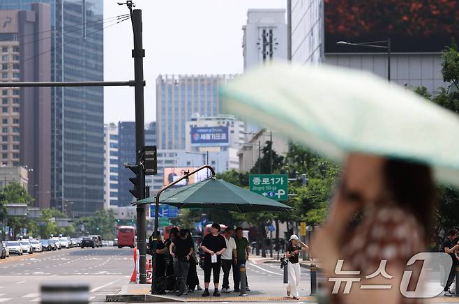 서울 전역에 올해 첫 폭염주의보가 발표된 29일 오후 서울 종로구 광화문 네거리에서 시민들이 횡단보도 그늘막 아래에 모여 햇볕을 피하고 있다. 2026.6.29 ⓒ 뉴스1 오대일 기자