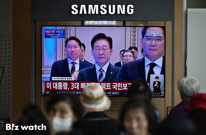 29일 오후 서울역 대합실에서 시민들이 이재명 대통령이 주재하는 3대 메가프로젝트 국민보고회를 TV 생중계로 시청하고 있다./사진=이명근 기자 qwe123@