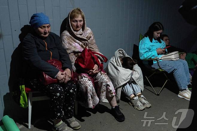 지난 6월 15일(현지시간) 러시아의 미사일 공격으로 파손된 키이우의 한 주거용 건물 밖에 주민들이 모여 있다. 러시아는 우크라이나 주요 도시들을 향해 대규모 미사일 공습을 감행해 우크라이나 수도 키이우의 역사적 건축물인 성모승천대성당에 화재를 일으키고 9명의 사망자를 냈다. 한편 우크라이나의 공격으로는 모스크바 남쪽 지역에서 3명이 숨졌다. 2026.06.15 ⓒ AFP=뉴스1