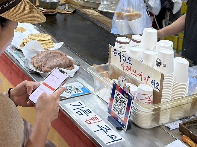 속초중앙시장에서 한 소비자가 디지털 온누리상품권을 이용해 호떡을 구매하고 있다. 사진=정원일 기자