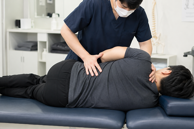 물리치료사가 환자에게 도수치료를 해주고 있는 모습을 구현한 이미지. 챗 GPT(지피티).