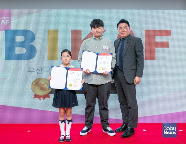 제6회 부산국제어린이청소년아트페어 미술공모전 KNN 대표이사상을 수상한 신정우 작가(가운데). 소장섭 기자 ⓒ베이비뉴스