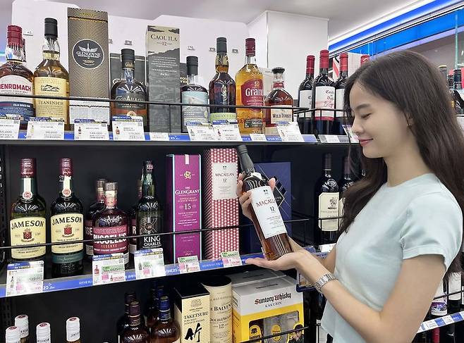GS25 모델이 매장에서 위스키를 소개하고 있다. GS25 제공