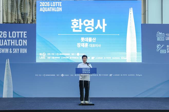 장재훈 롯데물산 대표이사가 12일 서울 송파구 롯데월드타워 앞에서 열린 2026 롯데 아쿠아슬론 개회식 무대에 올라 환영사를 하고 있다.(사진제공=롯데물산)