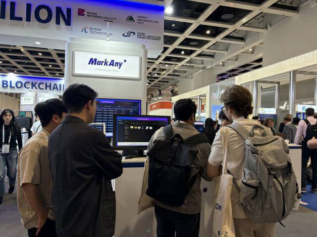 마크애니는 독일에서 최근 열린 'GITEX AI Europe 2026'에 부스를 마련했다. 부스를 찾은 글로벌 테크 관계자들이 마크애니의 위·변조 방지 디지털 자격증명 플랫폼(DCERT)에 대한 설명을 듣고 있다.
