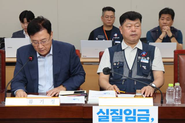 14일 정부세종청사 최저임금위원회에서 열린 제14차 전원회의에서 근로자위원인 류기섭 한국노총 사무총장이 사용자위원인 류기정 한국경영자총협회(경총) 전무의 발언을 듣고 있다. 연합뉴스