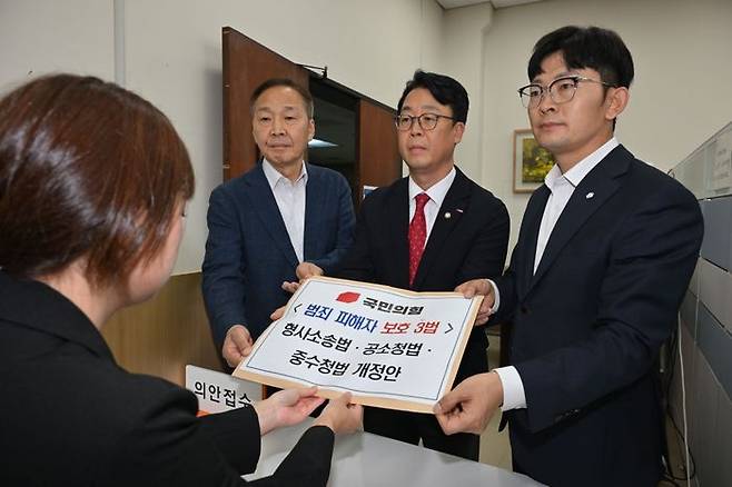 곽규택(가운데) 국민의힘 당 법률자문위원장 등 의원들이 범죄 피해자 보호 3법인 형사소송법·공소청법·중수청법 개정안을 15일 오후 서울 여의도 국회 의안과에 제출하고 있다. 왼쪽부터 국민의힘 김기웅 의원, 곽 위원장, 박충권 의원. ⓒ뉴시스