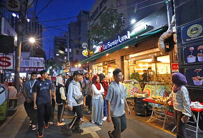 People walk past a clay oven and freshly baked somsa (meat pastries) displayed in front of an Uzbek restaurant on Central Asia Street in Jung District, central Seoul. PARK SANG-MOON