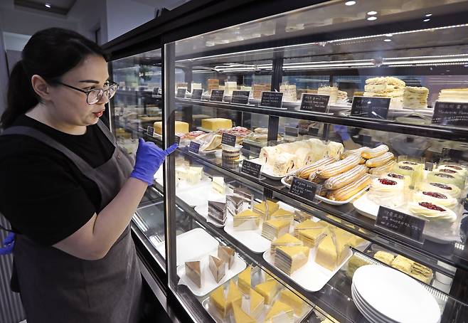 An employee points to one of the popular desserts sold at Russian Cakes. PARK SANG-MOON