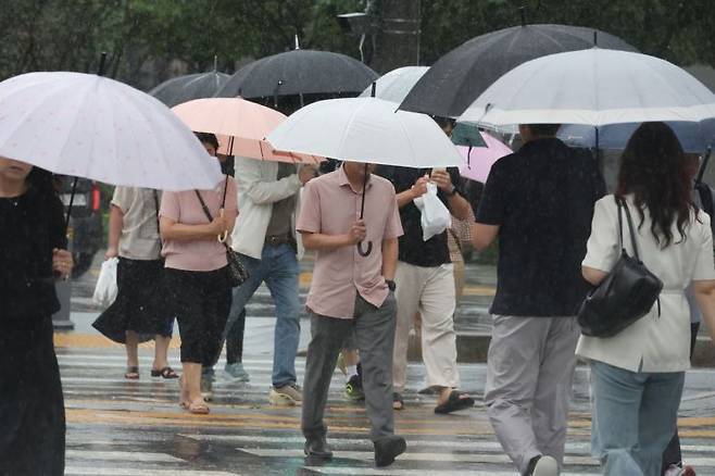 종로구 광화문광장 인근에서 우산을 쓴 시민들이 발걸음을 재촉하고 있다. 연합뉴스