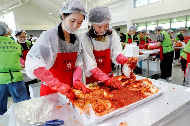 22일 광주김치타운에서 열린 2026 사랑의 김치나눔 행사에 참여한 광주신세계 임직원들이 정성껏 김치를 만들고 있다. /광주신세계 제공