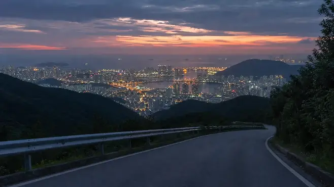 황령산 굽은 진입도로와 부산 도심 야경 조망