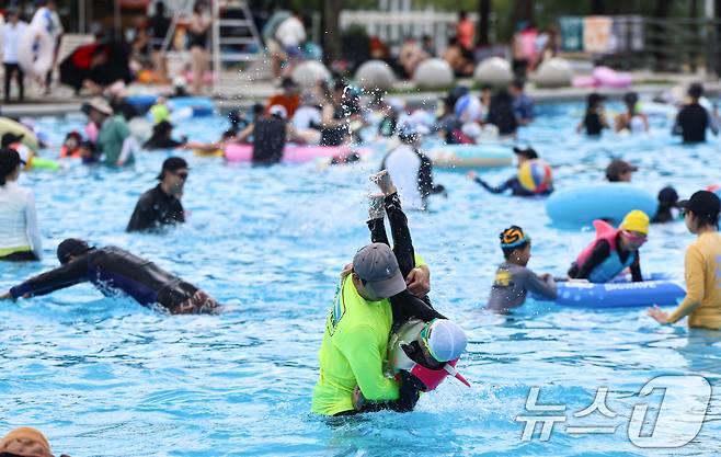 전국 대부분 지역에 폭염이 찾아온 26일 서울 광진구 뚝섬 한강공원 수영장을 찾은 시민들이 물놀이를 하며 더위를 식히고 있다. 2026.7.26 ⓒ 뉴스1 김도우 기자