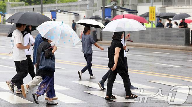 21일 서울 광화문 광장에서 시민들이 우산을 쓰고 이동하고 있다. 이날 기상청은 수도권을 중심으로 강한비가 내릴것으로 예보했다. 2026.7.21 ⓒ 뉴스1 김명섭 기자