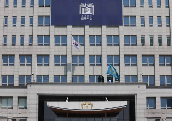 지난해 4월 4일 서울 용산구 대통령실에 걸려있던 봉황기(왼쪽)가 헌법재판소의 윤석열 대통령 탄핵 인용 이후 대통령실 관계자들에 의해 내려지고 있다. 대통령실사진기자단