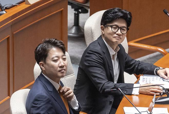 이준석 개혁신당 대표(앞)와 무소속 한동훈 의원이 지난 24일 국회에서 열린 예산결산위원회 전체 회의에 참석해 동료 의원들의 인사말을 듣고 있다. 연합뉴스