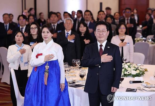 이재명 대통령, 산티아고 동포간담회 (산티아고<칠레>=연합뉴스) 한상균 기자 = 이재명 대통령과 김혜경 여사가 29일(현지시간) 칠레 산티아고 한 호텔에서 열린 동포 만찬간담회에서 국기에 경례하고 있다. 2026.7.30 xyz@yna.co.kr