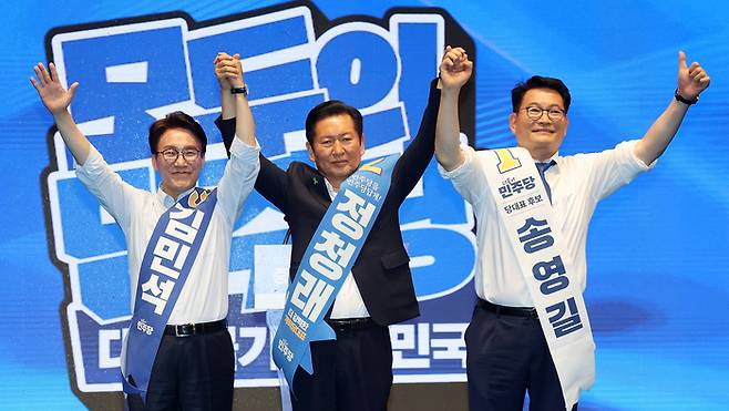 더불어민주당 당대표 경선에 출마한 김민석(왼쪽부터), 정청래, 송영길 후보가 1일 충북 청주시 CJB미디어센터에서 열린 당대표·최고위원 순회경선 합동연설회에서 손을 맞잡고 인사하고 있다. <연합뉴스>