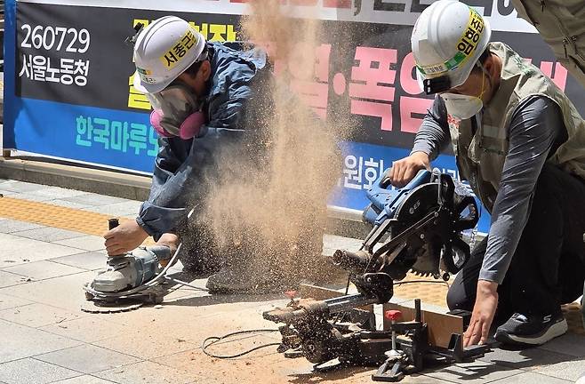 지난달 29일 서울 중구 서울고용노동청 본청 앞에서 건설현장 실내공정 노동자들이 작업 시연에 나선 모습. 한국마루노동조합, 권리찾기 유니온 등은 폭염 속 실내 작업자들도 고온에 노출되고 있지만 관련 대책은 부족하다고 지적했다. 노유림 기자