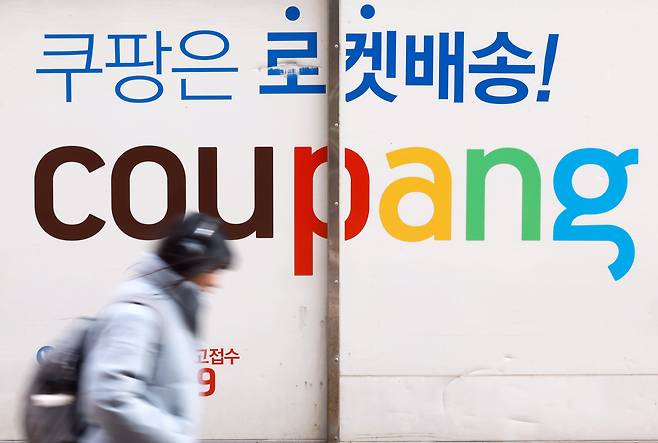 서울 시내에 주차된 쿠팡배송 차량 앞을 시민이 지나가고 있다./뉴스1
