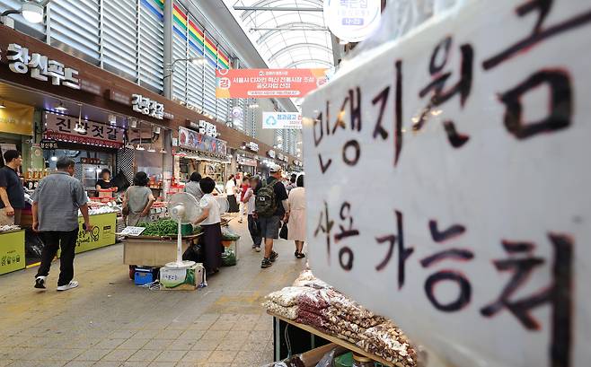 지난해 7월 서울 동대문구 청량리종합시장에 민생회복 소비쿠폰 사용가능 점포 안내문이 붙어 있다. /뉴스1