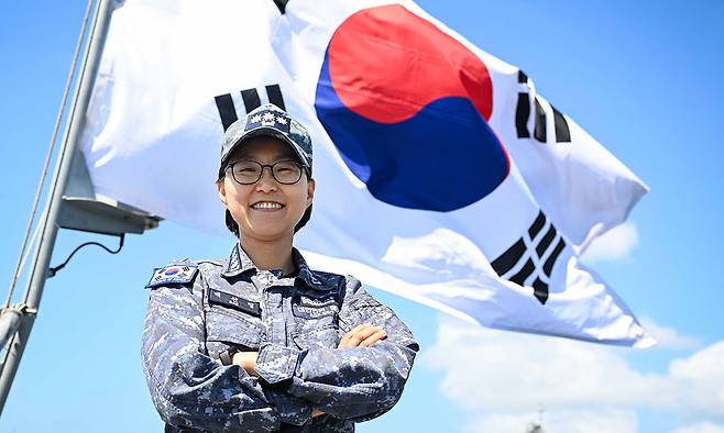 해군 대형 수송함인 독도함(1만4500t급) 함장에 임명된 배선영 대령이 태극기 앞에서 기념촬영을 하고 있다. 대령이 지휘하는 대형 함정에 여군이 함장으로 임명된 것은 해군 역사상 처음이다. 해군 제공