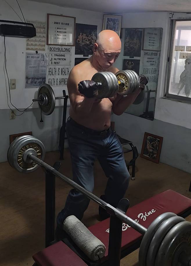 국내 최고령 보디빌더 서영갑씨가 지난 4월 대구 수성구 자택 안 체육관에서 양손으로 40㎏짜리 덤벨을 거뜬히 들어올리고 있다. 정확한 자세를 유지하며 올렸다 내리기 15회 반복했다. 김서원 기자