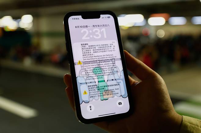 10일 대만 타이중에서 한 시민이 모바일 인터넷 속도 저하 모의 훈련 안내 문자를 보고 있다. EPA연합뉴스