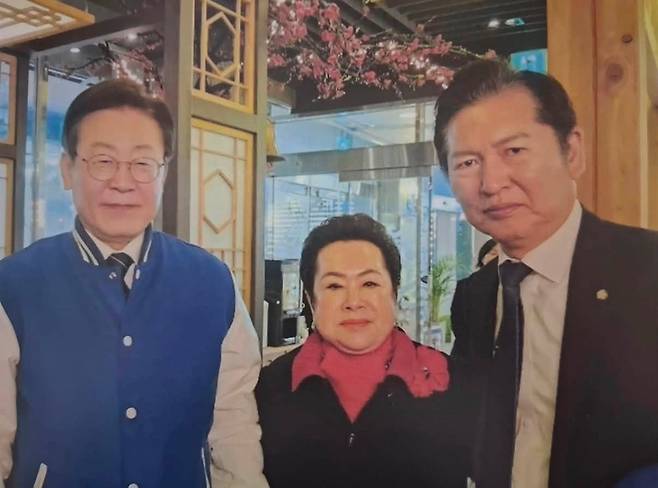 지난 2024년 3월 18일 마포의 한 식당에서 찍힌 이재명 당시 더불어민주당 대표, 이희자 한국근우회 회장 정청래 의원 사진. 최근 편집 논란이 벌어진 이재명, 이희자 2인만 등장하는 사진의 원본으로 추정되고 있다. SNS 캡처