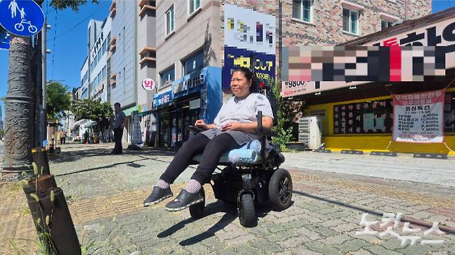 횡단보도에서 신호를 기다리는 전미영 씨. 건물 앞에 드리워진 그늘에 들어가기에 휠체어 부피가 너무 크다. 심동훈 기자