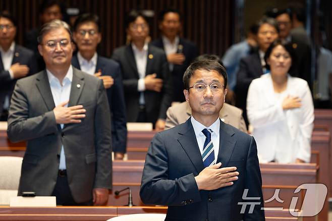 한병도 더불어민주당 당대표 직무대행 겸 원내대표를 비롯한 의원들이 지난달 30일 서울 여의도 국회에서 열린 의원총회에서 국민의례를 하고 있다. 2026.7.30 ⓒ 뉴스1 유승관 기자