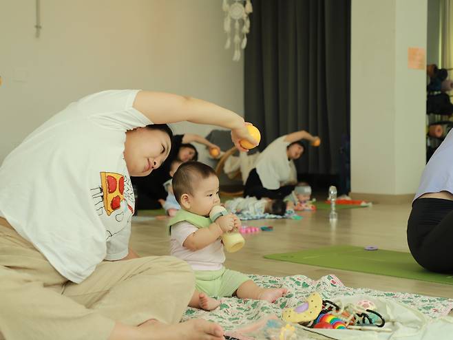 지난 11일 '유아 동반 프로그램'을 운영하는 서울 송파구의 한 요가원. 운동을 하는 엄마 옆에서 한 아이가 젖병을 물고 있다./이성현 인턴기자