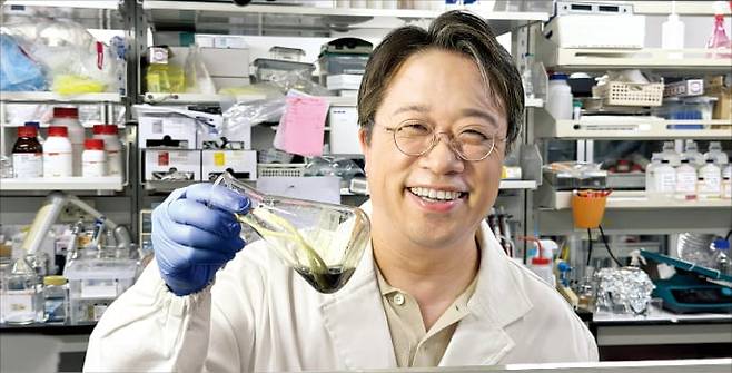 이해신 교수가 대학 실험실에서 폴리페놀 시료가 든 용기를 들어 보이고 있다.