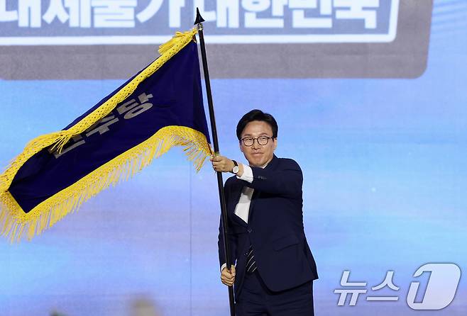 김민석 신임 더불어민주당 대표가 17일 오후 대전 유성구 DCC대전컨벤션센터에서 열린 '더불어민주당 제3차 정기전국당원대회'에서 당기를 흔들고 있다. 2026.8.17 ⓒ 뉴스1 황기선 기자