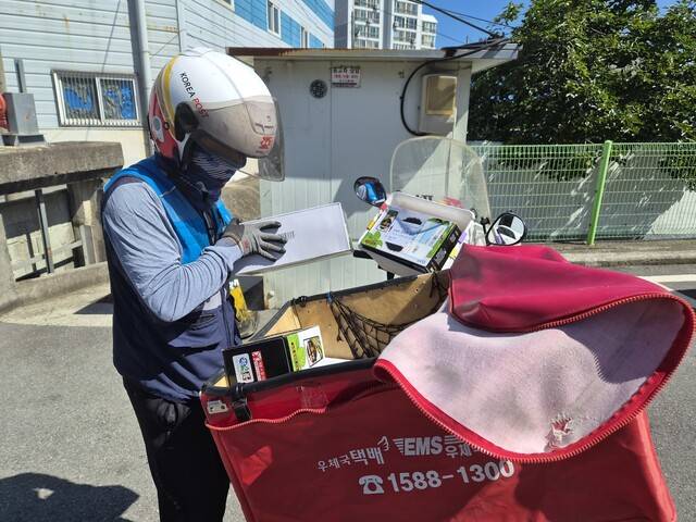 장흥우체국 집배원 박주한씨가 지난 12일 장흥군에서 마련한 두유 한 상자를 안부살핌 서비스 대상자들에게 전달하기 위해 분류하고 있다. 기민도 기자 key@hani.co.kr